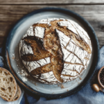 Bauernbrot mit Sauerteig 88 Frisch gebackenes Bauernbrot mit Sauerteig mit knuspriger Kruste, rustikalem Ausbund und lockerer Krume auf einem Keramikteller