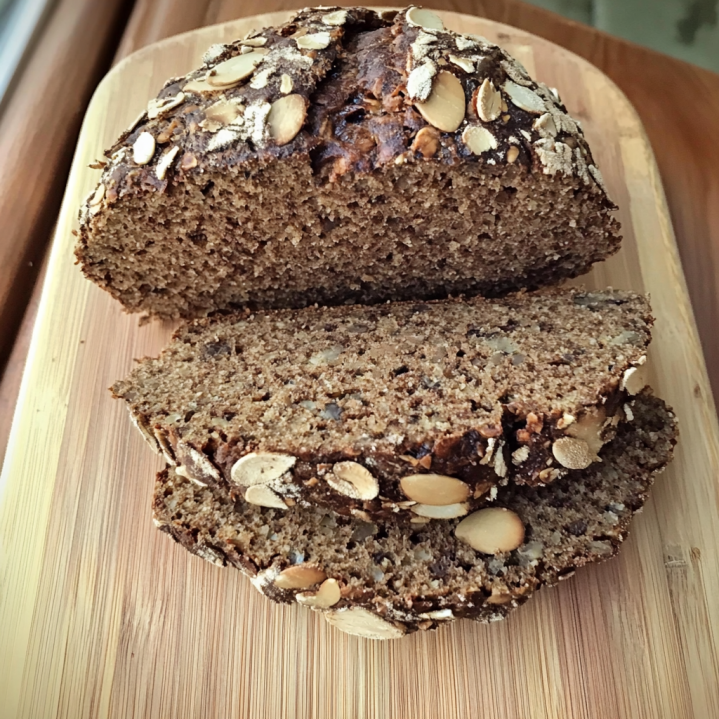 Brot ohne Kohlenhydrate mit Saaten und knuspriger Kruste auf einem Holzbrett