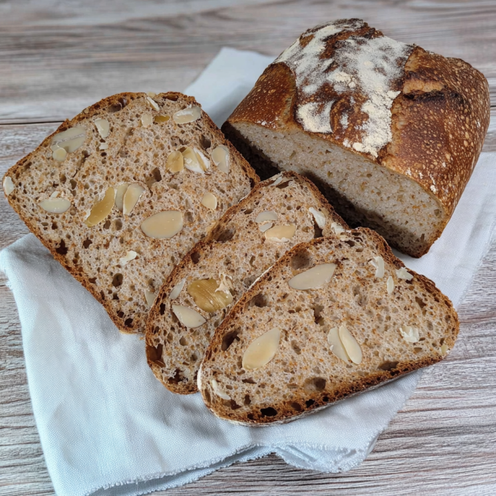 Haselnussbrot mit knuspriger Kruste und sichtbaren Haselnüssen in den aufgeschnittenen Brotscheiben.