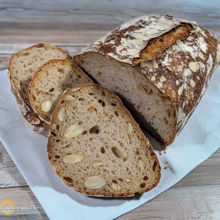 Frisch gebackenes Haselnussbrot mit knuspriger Kruste und sichtbaren Haselnüssen in den aufgeschnittenen Brotscheiben.